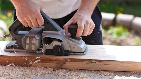 Mann mit Elektrohobel Seitenansicht Querformat Mann mit Elektrohobel Seitenansicht Querformat