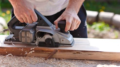 Mann mit Elektrohobel Seitenansicht Querformat Mann mit Elektrohobel Seitenansicht Querformat